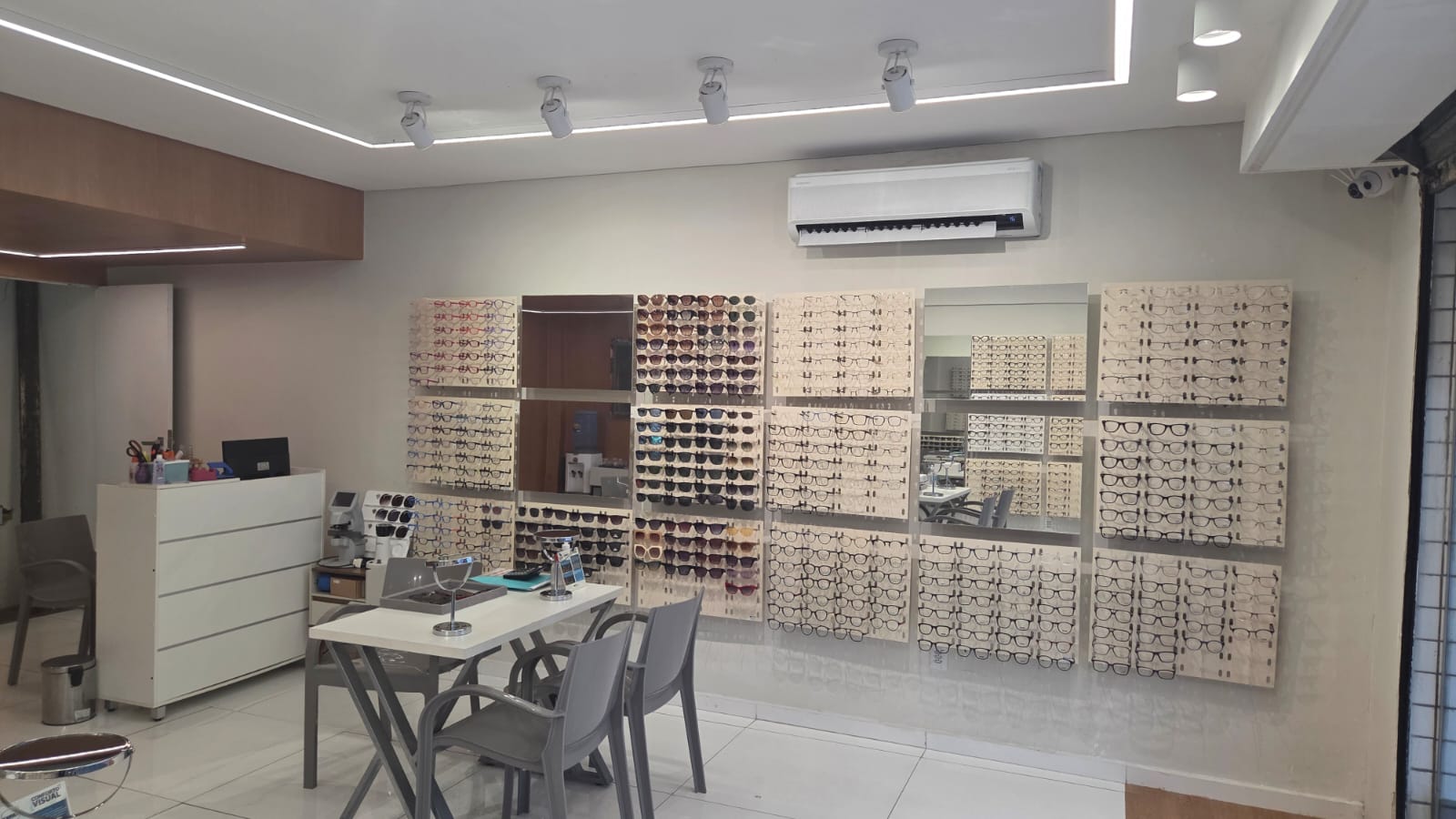 Salão da Ótica Moderna com armações organizadas e mesas de atendimento